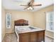 Well-lit bedroom featuring neutral walls, two windows, a ceiling fan, and a wood-frame bed at 2635 Manatee Harbor Dr, Ruskin, FL 33570