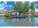 Waterfront dock with boat lift and cover. Mature trees provide shade over the water at 2635 Manatee Harbor Dr, Ruskin, FL 33570