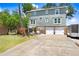 Charming two-story home with a stone facade and lush green lawn, providing curb appeal at 2635 Manatee Harbor Dr, Ruskin, FL 33570