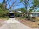 Charming single-story home with mature trees, a covered carport, and a welcoming entrance at 3021 W Helen Ave, Tampa, FL 33611