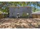 View of the back of the house with a spacious backyard and a wooden fence at 3115 W Wyoming Ave, Tampa, FL 33611