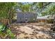 Shady backyard with a stone pathway leading up to the back of the house with wooden fencing at 3115 W Wyoming Ave, Tampa, FL 33611