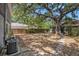 A spacious backyard featuring a large tree providing ample shade, with a wooden fence and stone pathway at 3115 W Wyoming Ave, Tampa, FL 33611