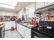 Practical kitchen with tiled floors, white cabinets, and black appliances at 3115 W Wyoming Ave, Tampa, FL 33611