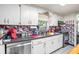 Traditional kitchen with white cabinets, mosaic backsplash, and stainless steel dishwasher at 3115 W Wyoming Ave, Tampa, FL 33611
