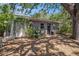 Outbuilding in backyard with light gray siding, white door, and surrounded by trees at 3115 W Wyoming Ave, Tampa, FL 33611