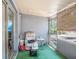 Enclosed porch featuring gray walls, green carpet, and a comfortable recliner at 3115 W Wyoming Ave, Tampa, FL 33611