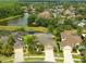 Aerial view of homes with a pond and mature trees showcasing the tranquil and well-planned community at 3254 Grassglen Pl, Wesley Chapel, FL 33544