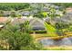 Aerial view of a property with a screened-in pool, lush greenery, and a serene pond setting at 3254 Grassglen Pl, Wesley Chapel, FL 33544