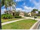 Single-story home with manicured lawn, mature palms, and a neatly edged driveway at 3254 Grassglen Pl, Wesley Chapel, FL 33544