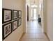 Inviting hallway featuring tile floors and decorative Gathering photo gallery wall at 3254 Grassglen Pl, Wesley Chapel, FL 33544
