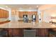 Kitchen boasts a large island with granite countertops and wooden cabinetry at 3254 Grassglen Pl, Wesley Chapel, FL 33544