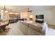 Open-concept living room flows into kitchen with breakfast bar and adjacent pool table room at 3254 Grassglen Pl, Wesley Chapel, FL 33544