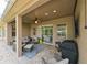 Covered patio with comfortable seating, ceiling fan, outdoor grill and view of the backyard pool at 3254 Grassglen Pl, Wesley Chapel, FL 33544