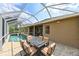 Covered patio with comfortable seating and table, and an inviting pool for outdoor living at 3254 Grassglen Pl, Wesley Chapel, FL 33544