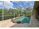 Screened-in pool area with a lounge chair, lush foliage, and a glimpse of the sky at 3254 Grassglen Pl, Wesley Chapel, FL 33544