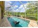 A serene screened-in pool area for relaxation and recreation with an outdoor dining set at 3254 Grassglen Pl, Wesley Chapel, FL 33544