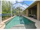 The screened-in pool features a spa and is surrounded by lush landscaping and privacy at 3254 Grassglen Pl, Wesley Chapel, FL 33544