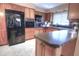 Well-lit kitchen with wood cabinets, tile flooring, modern appliances, and a breakfast bar at 3306 Lacewood Rd, Tampa, FL 33618