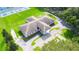 An aerial view displays the building's design with tennis courts and ample parking in a serene, wooded setting at 36848 Beth Ave, Zephyrhills, FL 33542