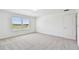 Neutral bedroom with carpet, a bright window, and a white door at 37194 Clinch Cir, Zephyrhills, FL 33540