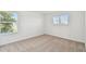 Bright bedroom featuring neutral carpet, white walls, and natural light from dual windows at 37194 Clinch Cir, Zephyrhills, FL 33540