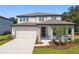 Beautiful two-story home featuring a covered entry, two car garage, and tastefully landscaped front yard at 37194 Clinch Cir, Zephyrhills, FL 33540