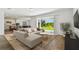 Bright living room with plush sectional sofa, open floor plan, and sliding glass doors to the backyard at 37194 Clinch Cir, Zephyrhills, FL 33540