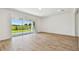 Bright, empty living room with sliding glass doors to outdoor space and wood-style tile flooring at 37194 Clinch Cir, Zephyrhills, FL 33540