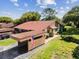 Aerial view of home with carport, lush lawn, mature trees, and new roof at 4016 Lighthouse Way, New Port Richey, FL 34652