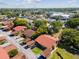 An aerial view of the neighborhood, showcasing red roofs, green trees, and carports with vehicle parking at 4016 Lighthouse Way, New Port Richey, FL 34652