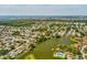 Aerial view displaying the neighborhood with lush trees, tranquil lake, and easy access to beaches at 4016 Lighthouse Way, New Port Richey, FL 34652
