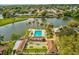 An aerial view showcases the neighborhood's serene lake, community pool, and tropical landscaping at 4016 Lighthouse Way, New Port Richey, FL 34652