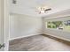 Vacant bedroom with wood-look floors, a ceiling fan, and a window providing natural light at 4016 Lighthouse Way, New Port Richey, FL 34652