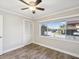 Cozy bedroom with wood floors, ceiling fan, and a closet to the left of the window at 4016 Lighthouse Way, New Port Richey, FL 34652