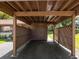 Carport featuring brown painted wood and a storage shed with a door that reads, 