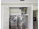 Laundry room with modern, front-load washer and dryer machines and a water heater at 4016 Lighthouse Way, New Port Richey, FL 34652
