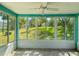 Sunroom with tile floor, ceiling fan, and large windows overlooking the green backyard at 4016 Lighthouse Way, New Port Richey, FL 34652