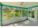 Bright sunroom with tile floor, ceiling fan, and large windows providing a scenic backyard view at 4016 Lighthouse Way, New Port Richey, FL 34652