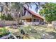 Spacious backyard showcasing a charming log cabin-style home, mature trees, and lounging areas at 4126 Burrows Rd, Zephyrhills, FL 33542