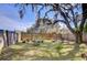Fenced backyard featuring lush greenery, mature trees and cozy patio seating for outdoor relaxation at 4126 Burrows Rd, Zephyrhills, FL 33542