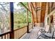 Covered balcony with wood paneling and chairs offering a tranquil outdoor space with scenic views at 4126 Burrows Rd, Zephyrhills, FL 33542