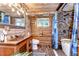 Charming bathroom with a hammered copper sink, wooden walls, and a stone-look shower at 4126 Burrows Rd, Zephyrhills, FL 33542