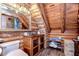 Rustic bathroom featuring log walls, copper sink, and a decorative mirror providing an inviting and natural aesthetic at 4126 Burrows Rd, Zephyrhills, FL 33542