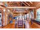 Open-concept dining area features wood flooring, unique log walls, and an adjacent kitchen with modern appliances at 4126 Burrows Rd, Zephyrhills, FL 33542