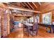 Well-lit dining area with log walls, offering a rustic and inviting atmosphere adjacent to the modern kitchen at 4126 Burrows Rd, Zephyrhills, FL 33542