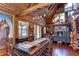 Charming dining area with log walls, natural light, and an open layout leading to the fireplace and living area at 4126 Burrows Rd, Zephyrhills, FL 33542