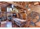 Inviting dining area features log walls and staircase, with an open layout offering access to the living and fireplace at 4126 Burrows Rd, Zephyrhills, FL 33542