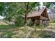 Charming two-story log home featuring a metal roof, wraparound porch and mature trees at 4126 Burrows Rd, Zephyrhills, FL 33542