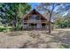 Charming two-story log home featuring a metal roof, wraparound porch and mature trees at 4126 Burrows Rd, Zephyrhills, FL 33542